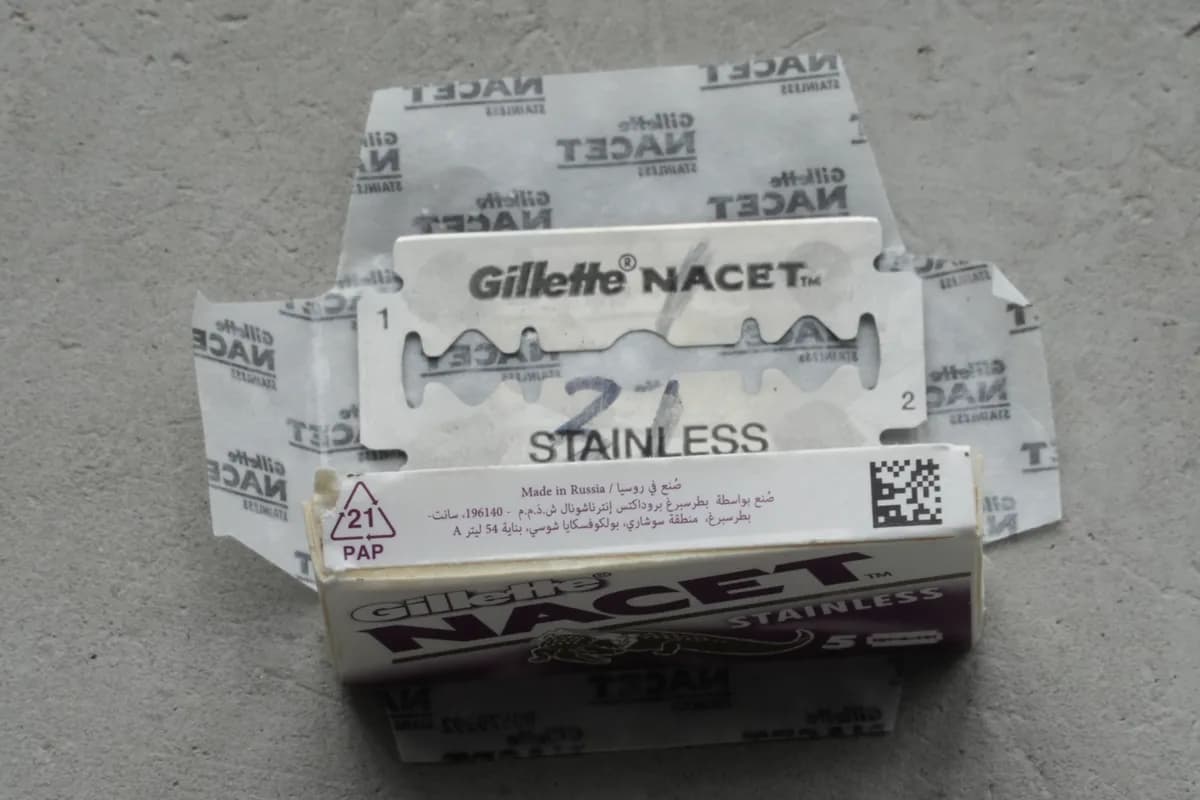 End panel of the Gillette Nacet box showing the English 'Made in Russia' origin line and the Petersburg Products International LLC, St. Petersburg manufacturer address, with a wax-paper-wrapped blade above it