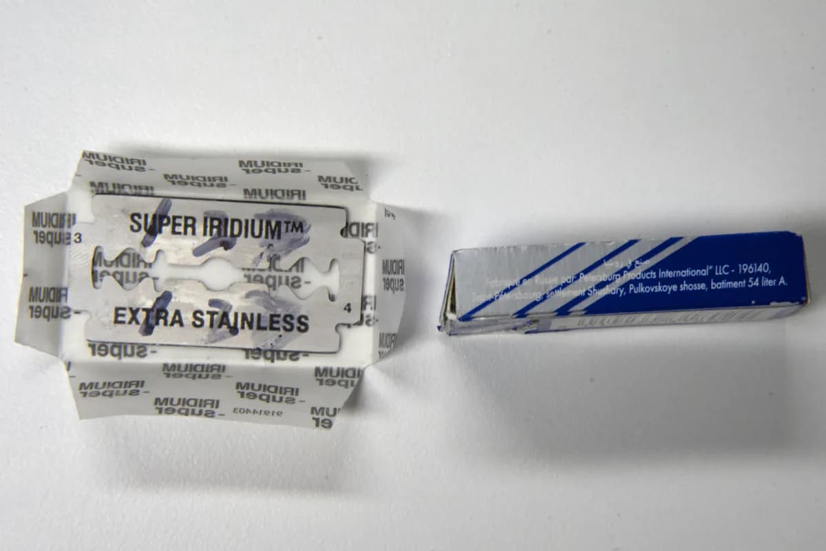 Side panel of the Iridium Super box showing the French origin line naming Russia and Petersburg Products International LLC with its St Petersburg address, beside an unwrapped blade stamped SUPER IRIDIUM EXTRA STAINLESS