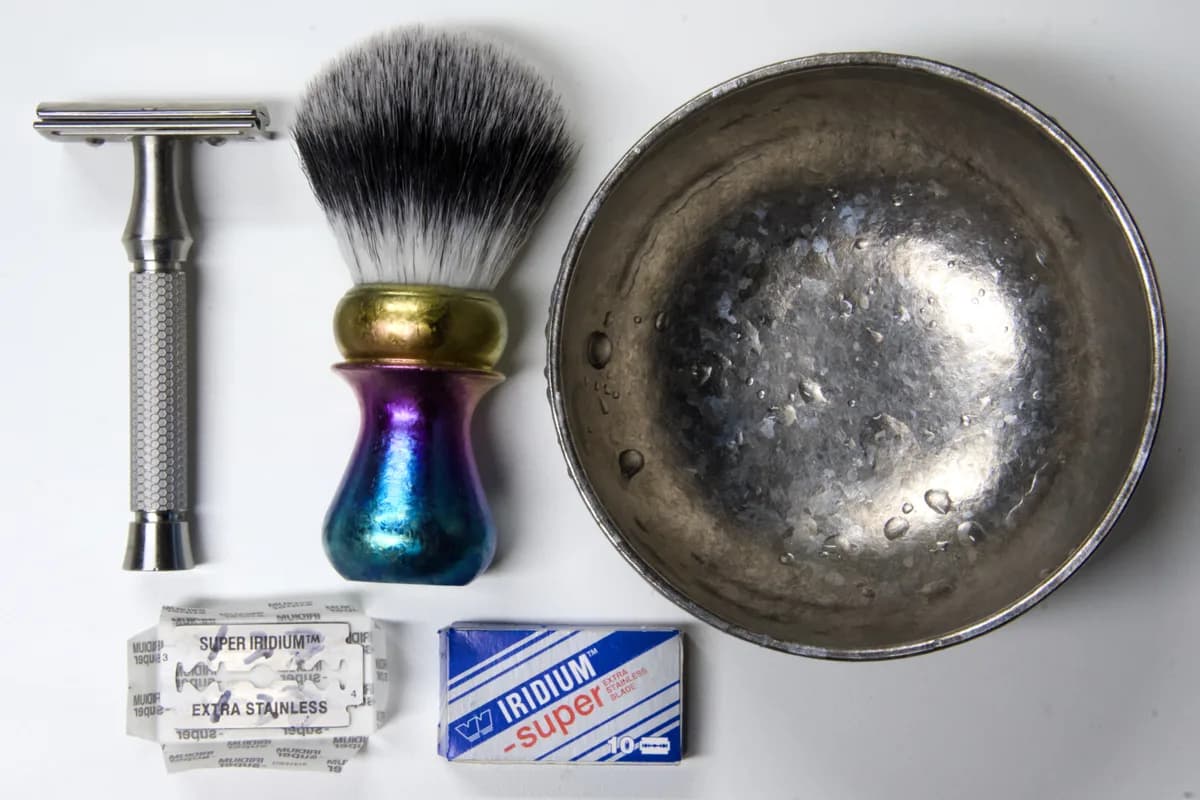 Iridium Super 10-blade pack and a wax-paper-wrapped blade next to the ORMIXA Vector 316L safety razor, an ORMIXA titanium bowl and a Harbor titanium-handled synthetic brush