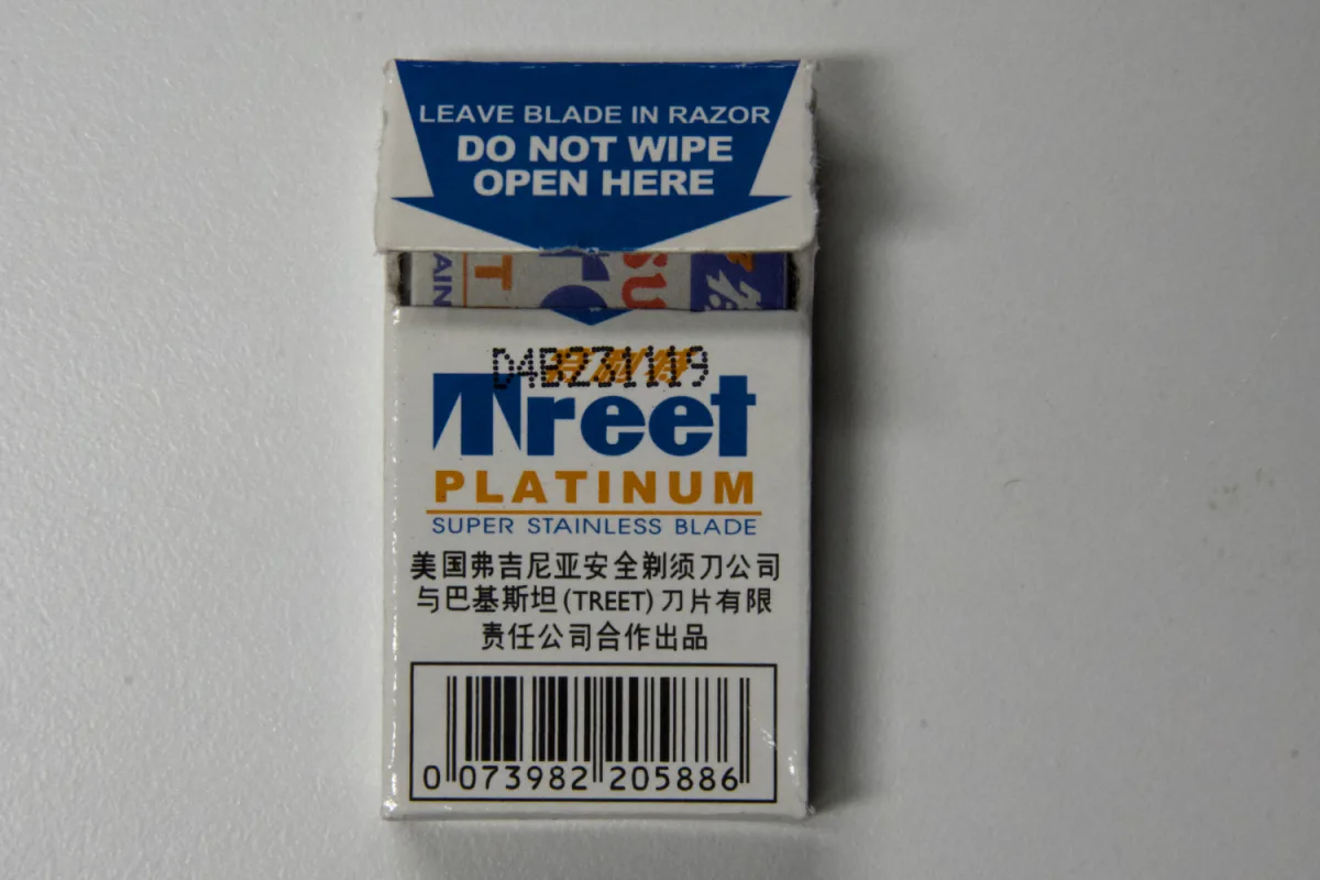 Back panel of the Super Treet Platinum pack with its top flap open, showing Treet PLATINUM SUPER STAINLESS BLADE, a three-line Chinese co-production statement and the barcode