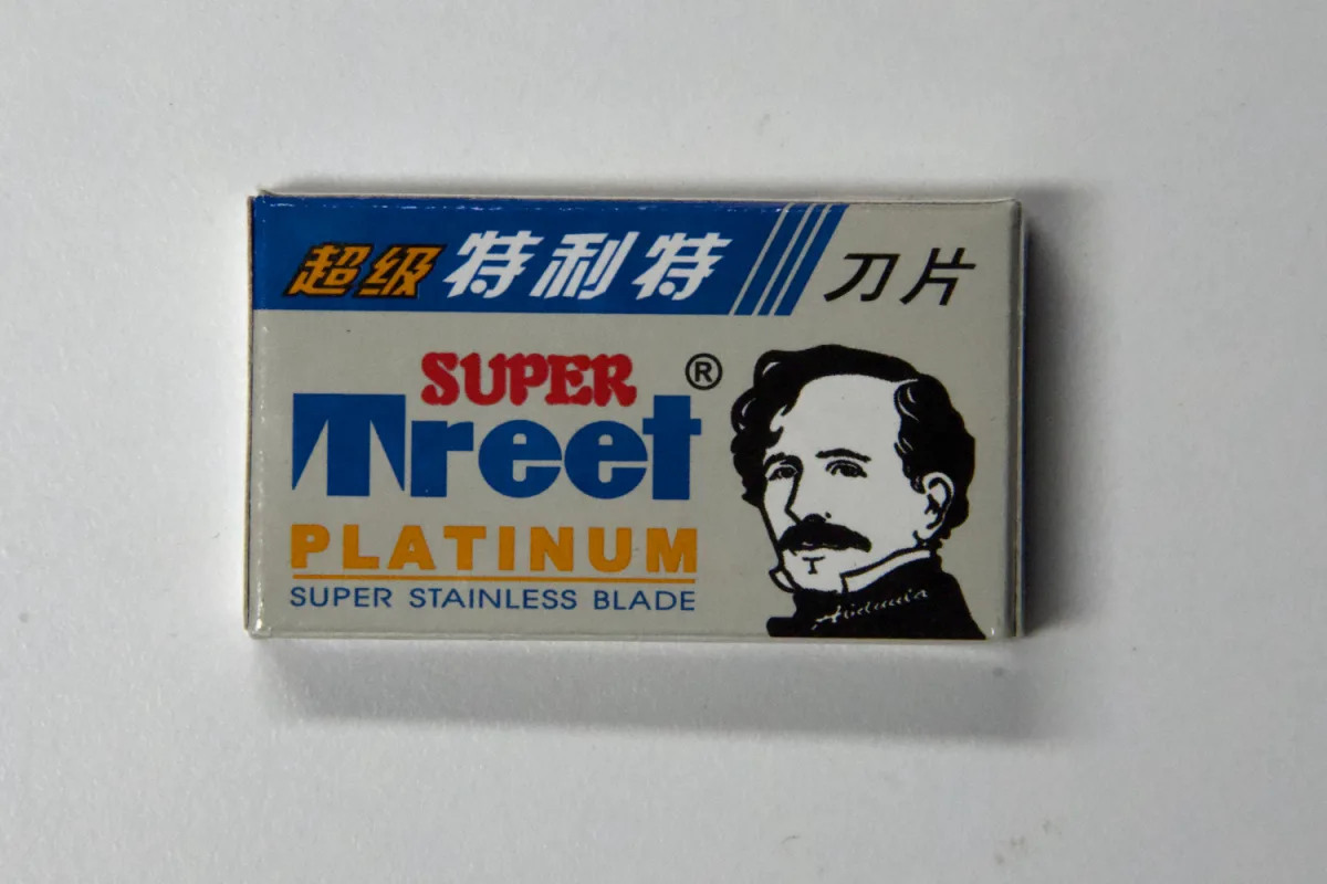 Front of the Super Treet Platinum pack reading 超级特利特 刀片, SUPER Treet, PLATINUM and SUPER STAINLESS BLADE beside a portrait