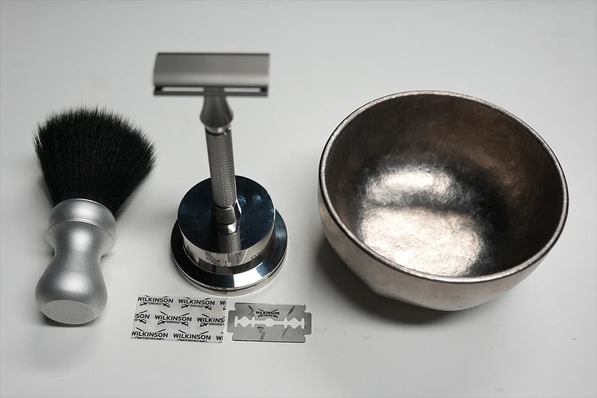 Wilkinson Sword Classic 5-blade Double Edge box, an ORMIXA Vector 316L stainless safety razor, and an ORMIXA Harbor 6061 Aluminum 24 mm Classic Tuxedo brush on a neutral surface