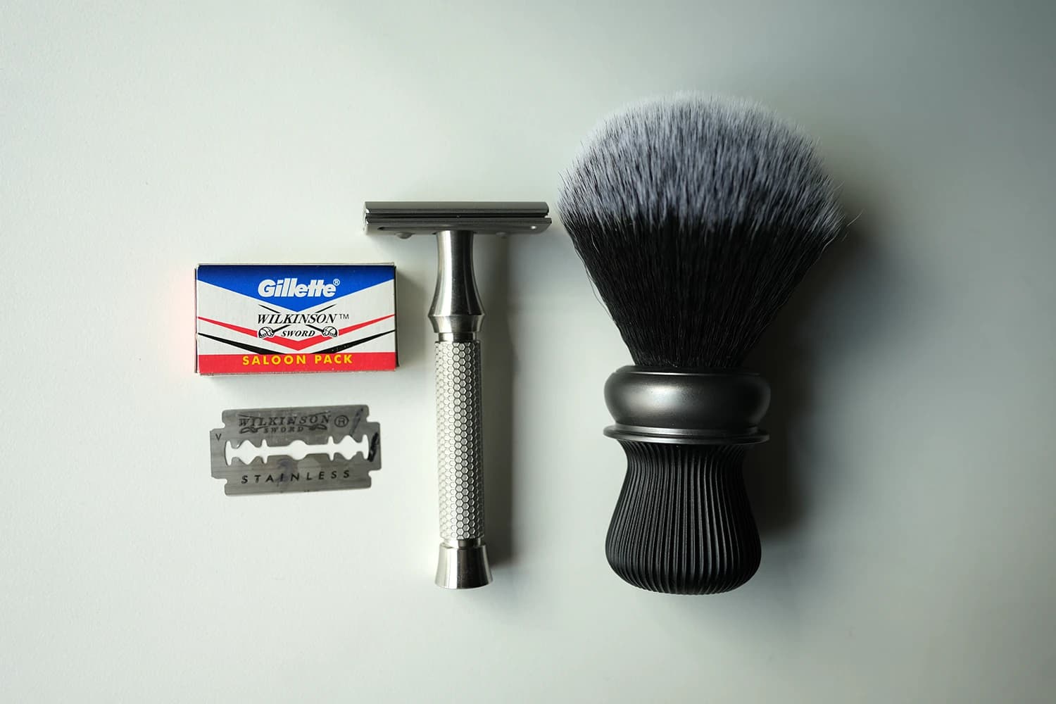 Wilkinson Sword Saloon Pack 5-pack box with Gillette and Wilkinson Sword co-branded labeling, an ORMIXA Vector 316L stainless safety razor, and an ORMIXA Harbor synthetic shaving brush on a neutral surface