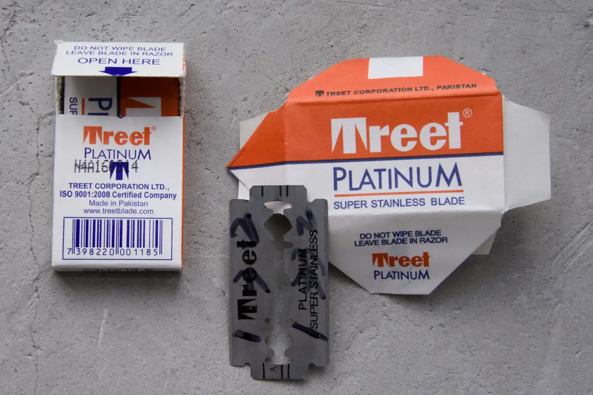 Back panel of the Treet Platinum pack showing TREET CORPORATION LTD., Made in Pakistan and the barcode, next to the opened paper wrapper and the stamped blade